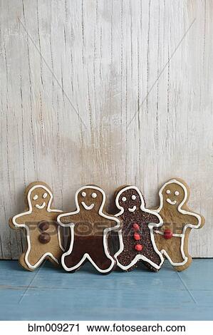 Stock Image - Four gingerbread man cookies in a row. Fotosearch