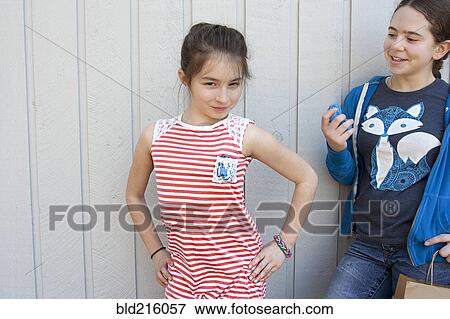 Friend watching girl posing at wall View Large Photo Image Stock Photo - Friend watching girl posing at wall. Fotosearch