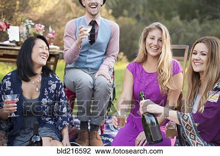 Friends drinking champagne at picnic in park View Large Photo Image Stock Image - Friends drinking champagne at picnic in park. Fotosearch