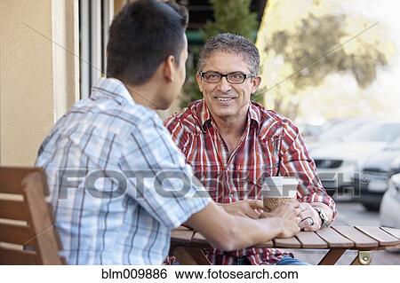 Stock Photograph - Friends drinking coffee at outdoor cafe. Fotosearch