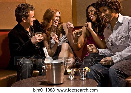 Friends drinking together in nightclub View Large Photo Image Stock Photo - Friends drinking together in nightclub. Fotosearch