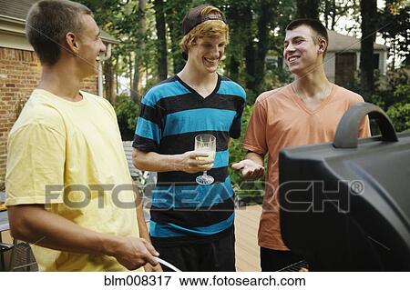 Stock Photo - Friends hanging out together barbecuing. Fotosearch
