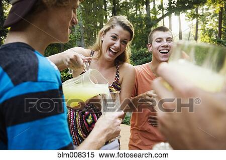 Friends hanging out together drinking lemonade View Large Photo Image Stock Photography - Friends hanging out together drinking lemonade. Fotosearch