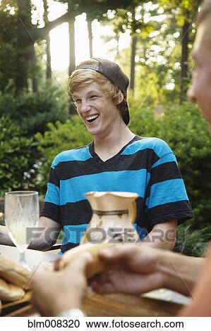 Friends hanging out together eating outdoors View Large Photo Image Stock Image - Friends hanging out together eating outdoors. Fotosearch