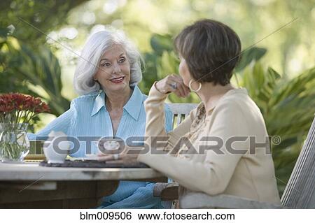 Friends having coffee on patio View Large Photo Image Stock Photograph - Friends having coffee on patio. Fotosearch