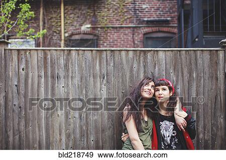 Friends hugging at wooden fence View Large Photo Image Stock Photo - Friends hugging at wooden fence. Fotosearch