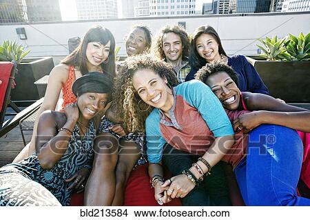 Picture - Friends hugging on urban rooftop. Fotosearch