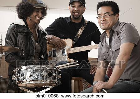 Stock Photo - Friends playing musical instruments in band. Fotosearch