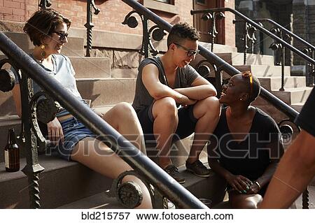 Stock Photo - Friends relaxing on front stoop. Fotosearch