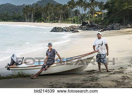 Stock Photo - Friends standing near boat on beach. Fotosearch