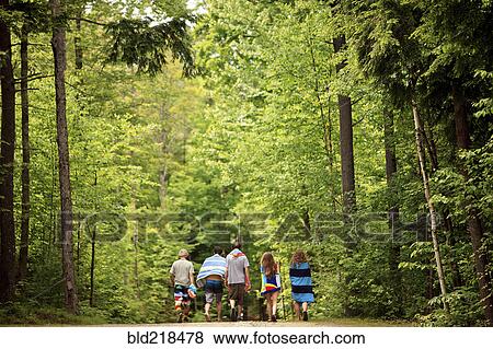 Stock Photo - Friends walking on dirt path in forest. Fotosearch