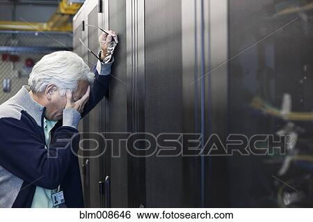 Frustrated Asian businessman working in office technology room View Large Photo Image Stock Photograph - Frustrated Asian businessman working in office technology room. Fotosearch