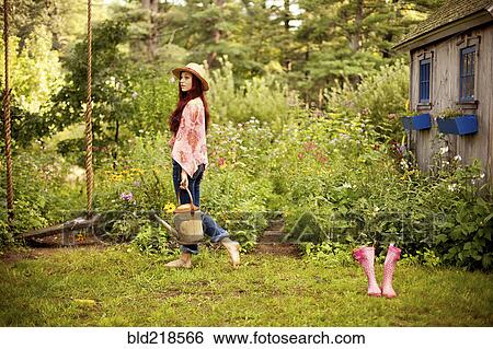 Stock Photograph - Gardener picking flowers in garden. Fotosearch