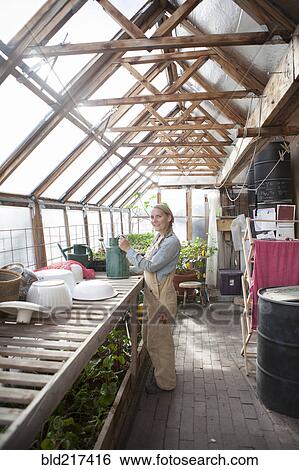 Stock Photograph - Gardener working in greenhouse. Fotosearch