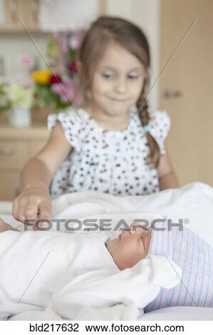 Girl admiring newborn sister on hospital bed View Large Photo Image Stock Image - Girl admiring newborn sister on hospital bed. Fotosearch