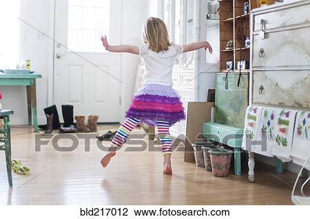Stock Image - Girl dancing in living room. Fotosearch