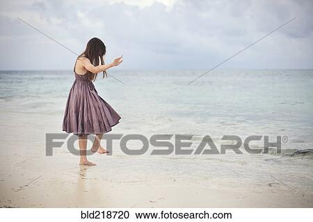 Girl dancing in waves on beach View Large Photo Image Stock Image - Girl dancing in waves on beach. Fotosearch