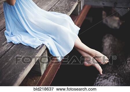 Girl dangling feet off wooden dock View Large Photo Image Stock Photo - Girl dangling feet off wooden dock. Fotosearch
