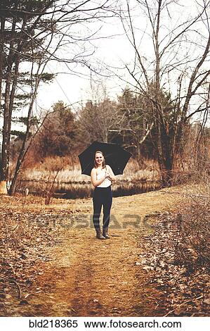 Stock Photography - Girl holding umbrella in park. Fotosearch