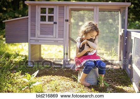 Girl hugging chicken in farm yard View Large Photo Image Stock Photo - Girl hugging chicken in farm yard. Fotosearch