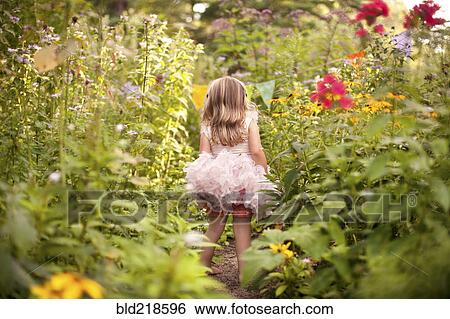 Girl in frilly dress exploring tall flowers View Large Photo Image Stock Photograph - Girl in frilly dress exploring tall flowers. Fotosearch