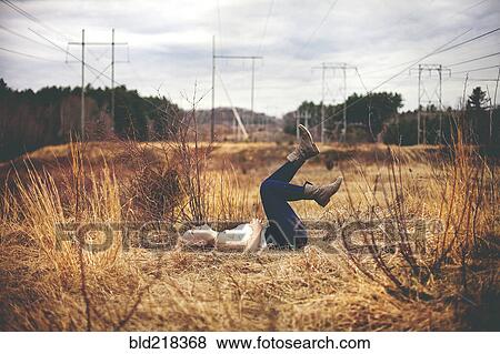 Girl laying on back in field View Large Photo Image Stock Photo - Girl laying on back in field. Fotosearch