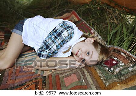 Stock Photo - Girl laying on blanket in camping tent. Fotosearch