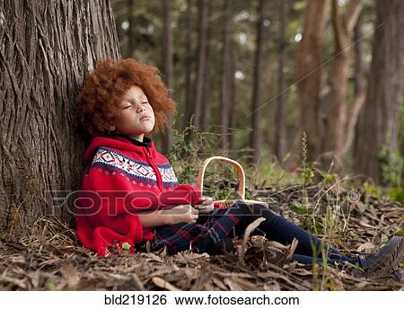 Stock Photograph - Girl napping under tree in park. Fotosearch
