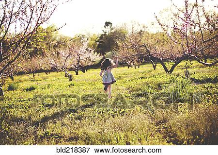 Girl playing in rural field View Large Photo Image Stock Photo - Girl playing in rural field. Fotosearch