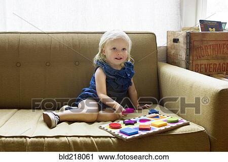 Girl playing with wooden blocks on sofa View Large Photo Image Stock Image - Girl playing with wooden blocks on sofa. Fotosearch