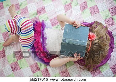 Girl reading book on blanket View Large Photo Image Stock Photography - Girl reading book on blanket. Fotosearch