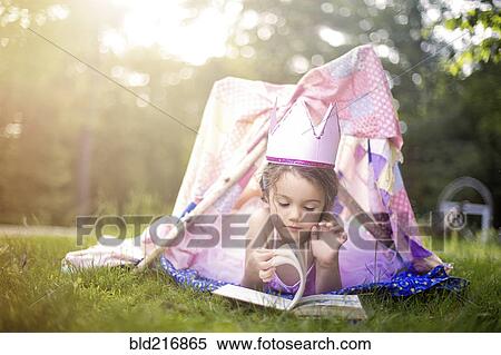 Stock Photography - Girl reading in tent in backyard. Fotosearch