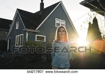 Girl smiling near house at sunset View Large Photo Image Stock Photo - Girl smiling near house at sunset. Fotosearch