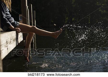 Stock Image - Girl splashing water in lake. Fotosearch