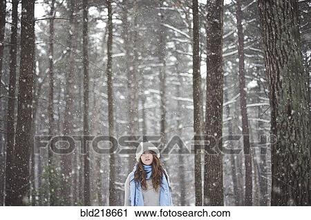 Stock Image - Girl standing in snowy forest. Fotosearch