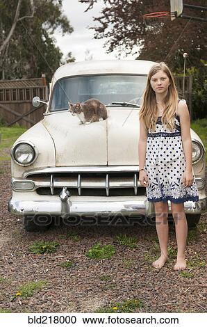 Girl standing near cat on vintage car View Large Photo Image Stock Image - Girl standing near cat on vintage car. Fotosearch