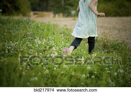 Picture - Girl walking in field of flowers. Fotosearch