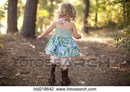 Stock Image - Girl walking on forest path. Fotosearch