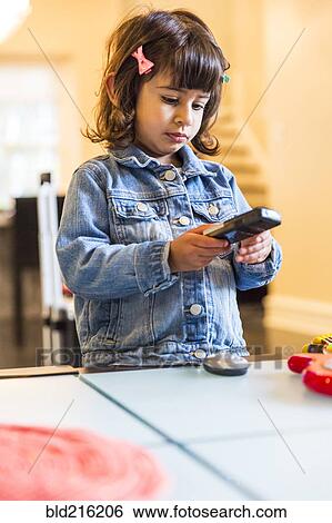 Stock Photograph - Girl watching television with remote control. Fotosearch