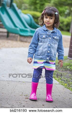 Stock Image - Girl wearing rain boots at playground. Fotosearch