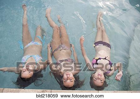 Girls floating in swimming pool View Large Photo Image Stock Photo - Girls floating in swimming pool. Fotosearch