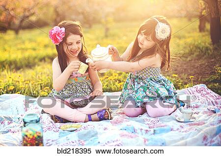 Girls having tea party picnic in rural field View Large Photo Image Stock Photography - Girls having tea party picnic in rural field. Fotosearch