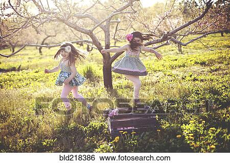 Girls playing in rural field View Large Photo Image Stock Photograph - Girls playing in rural field. Fotosearch