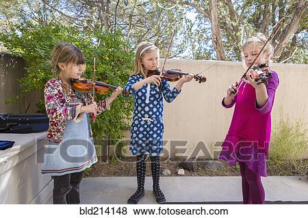 Stock Photo - Girls playing violin outdoors. Fotosearch