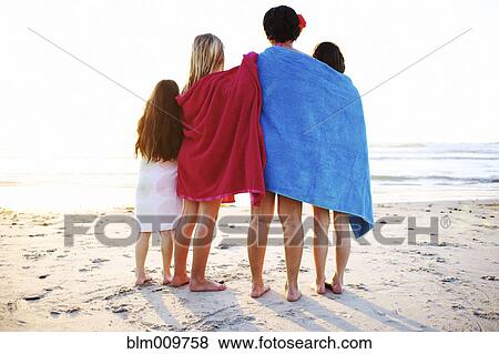 Girls wrapped in towels standing on beach View Large Photo Image Stock Photo - Girls wrapped in towels standing on beach. Fotosearch