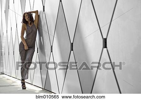 Stock Photography - Glamorous Caucasian woman leaning against wall. Fotosearch