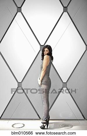 Glamorous Caucasian woman standing near wall View Large Photo Image Stock Photograph - Glamorous Caucasian woman standing near wall. Fotosearch