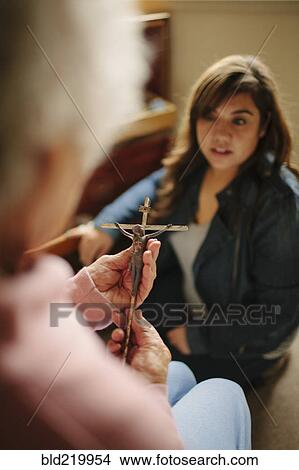 Granddaughter and grandmother praying with crucifix View Large Photo Image Picture - Granddaughter and grandmother praying with crucifix. Fotosearch