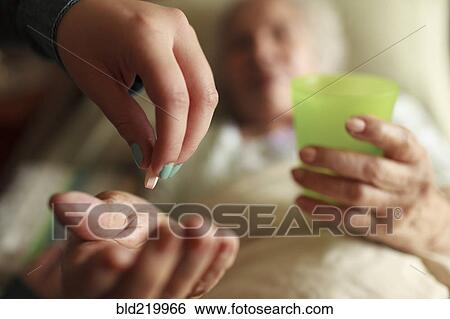 Granddaughter giving grandmother medication in bed View Large Photo Image Stock Photograph - Granddaughter giving grandmother medication in bed. Fotosearch