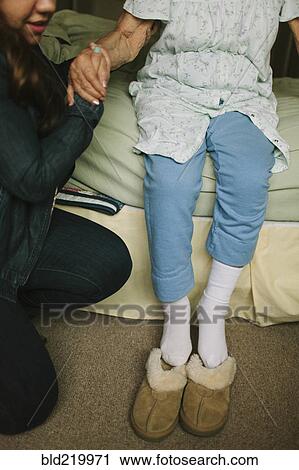 Granddaughter helping grandmother out of bed into slippers View Large Photo Image Stock Image - Granddaughter helping grandmother out of bed into slippers. Fotosearch